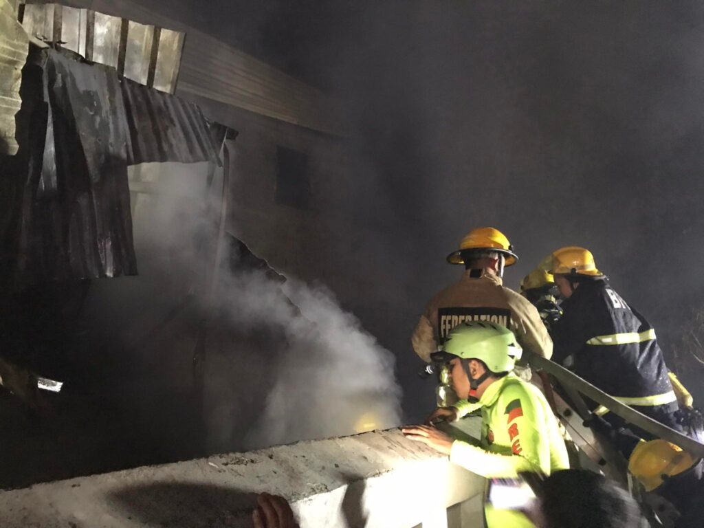 Members of the Bureau of Fire Protection seek ways to fight the fire in their effort to retrieve the 72-year old woman. | Photo by Aaron Lloyd Refoyo.